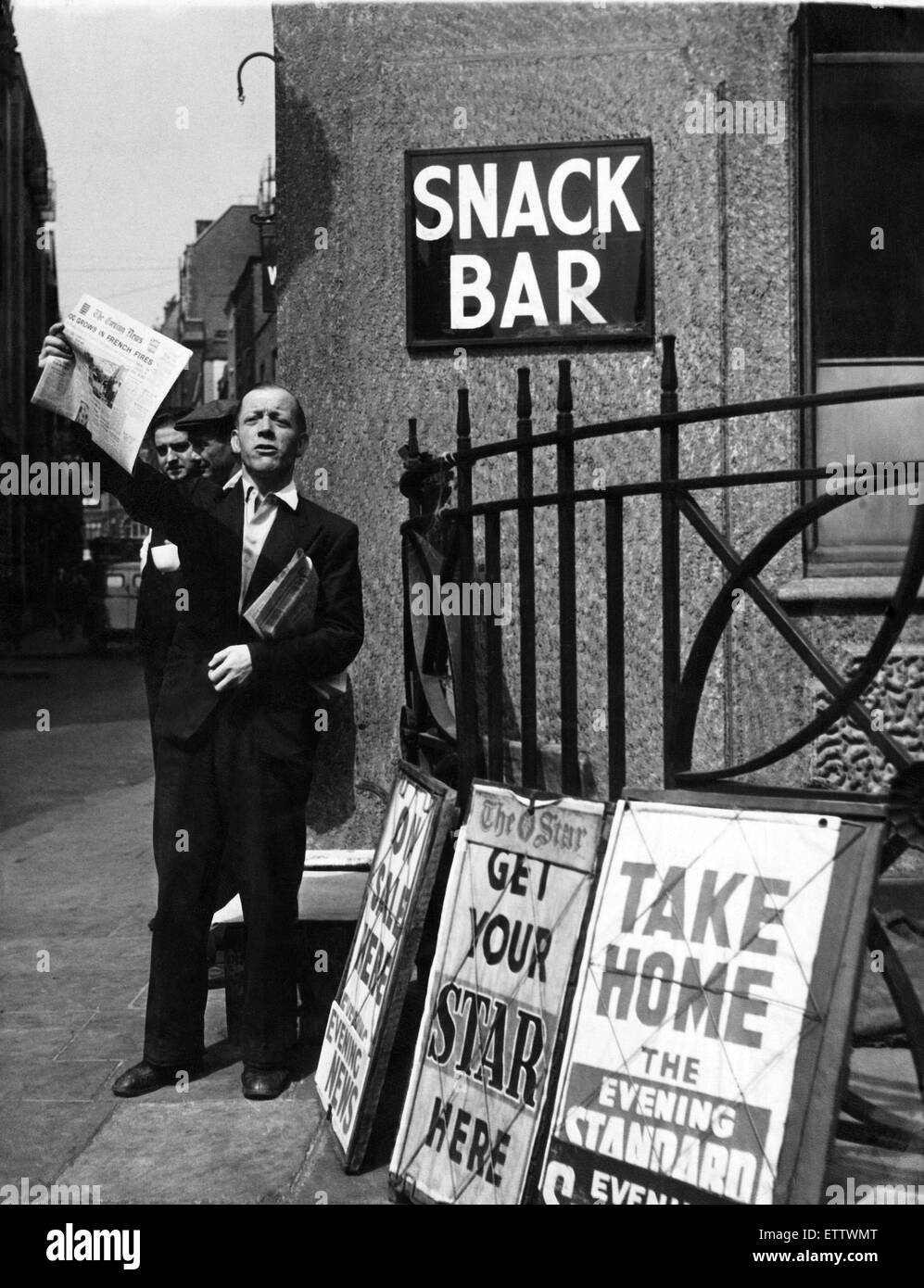 Un venditore di giornali a Londra, tenendo in mano una copia della serata News Giornale. Circa 1949. Foto Stock