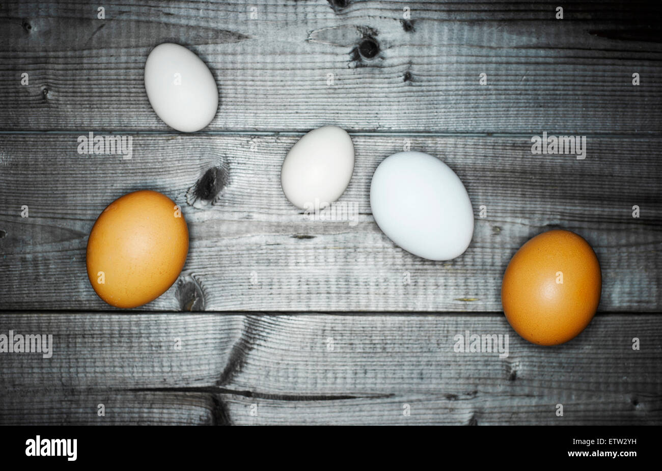 Due uova di colore marrone e bianco tre uova su legno Foto Stock