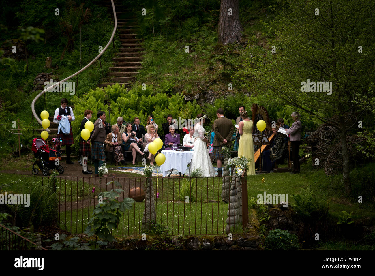 Una festa di nozze esterni; la sposa e lo sposo si stanno scambiando i loro voti davanti ai loro ospiti di nozze in corrispondenza di una ubicazione esterna Foto Stock