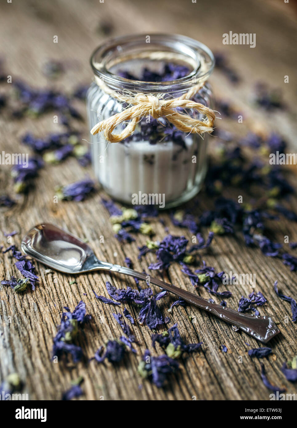 Il vasetto di vetro e i dolci violette su legno Foto Stock