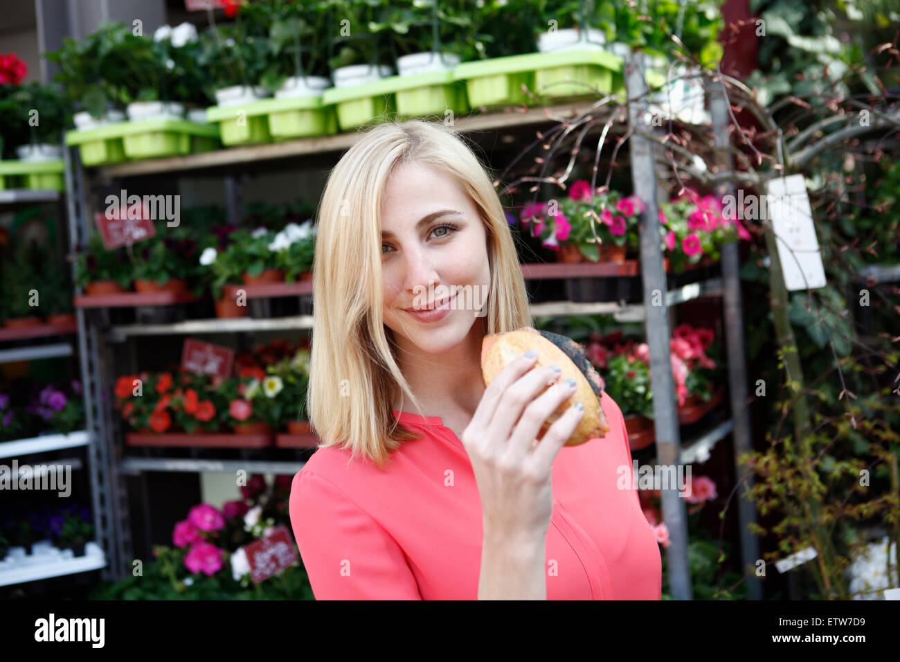 Sorridente donna bionda con rotolo di grano sul mercato settimanale Foto Stock