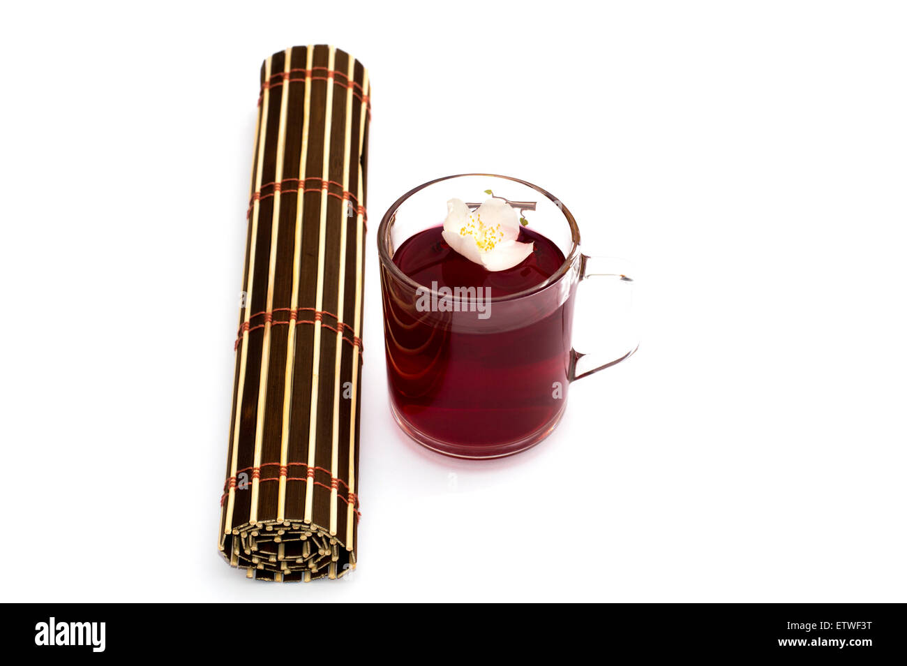 Bicchiere di tè rosso vicino al tappeto attorcigliati Foto Stock