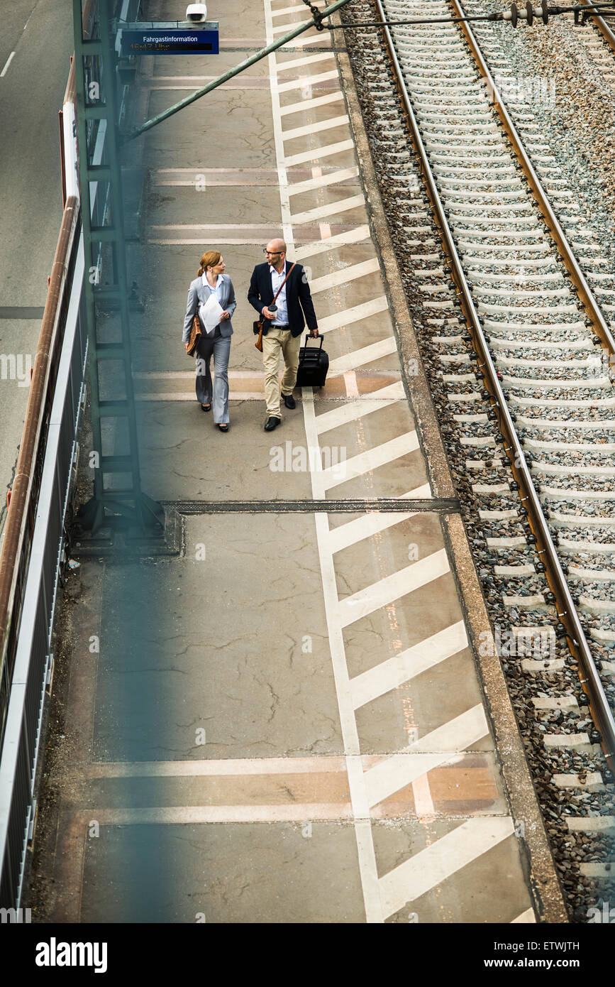 Imprenditore e imprenditrice camminando sulla piattaforma ferroviaria Foto Stock