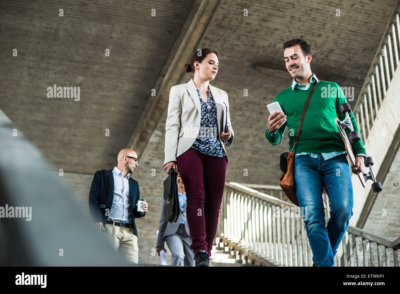 Quattro persone che camminano su scale Foto Stock