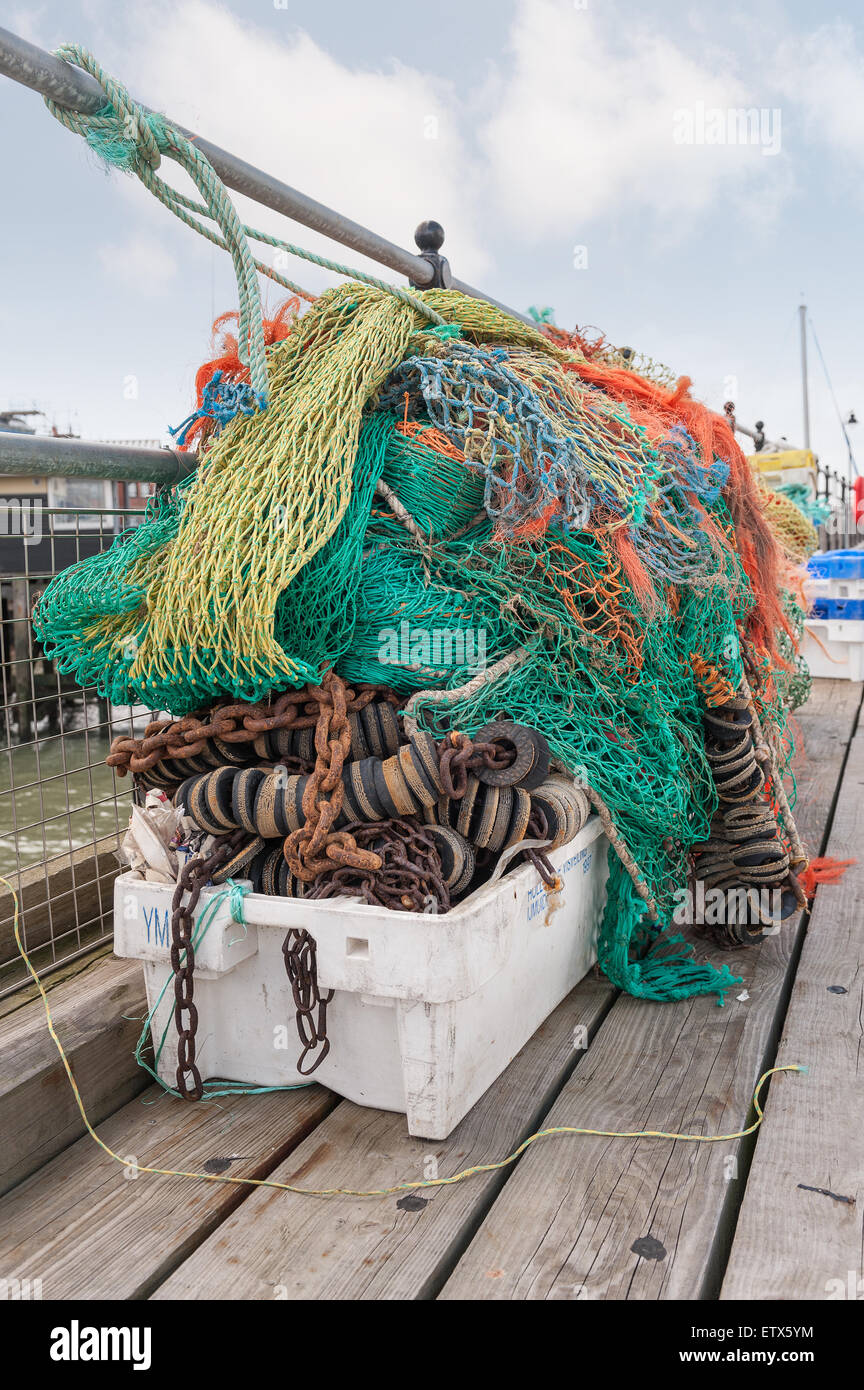 Impilati contenitore del pescatore con galleggianti netting varie dimensioni lato banchina pronto per la cattura di pesci colorati misti net vecchie e logore Foto Stock