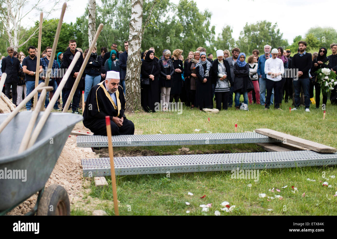 L Imam Abdallah Hajjir prega sulla tomba di una donna dalla Siria morti nel Mare Mediterraneo nella sezione musulmana del cimitero Berlin-Gatow a Berlino, Germania, 16 giugno 2015. Il funerale è un'azione organizzata dagli attivisti con il "Centro di Bellezza politico, ' che protestano contro l'UE della politica in materia di profughi. La donna di superstiti che vivono in Germania e concordati per l'azione non erano presenti. Contrariamente agli attivisti dichiarazione", della donna e del bambino che ha anche annegati in volo, non saranno sepolti con lei. Secondo gli attivisti, erano entrambi a bordo di una nave per i Foto Stock