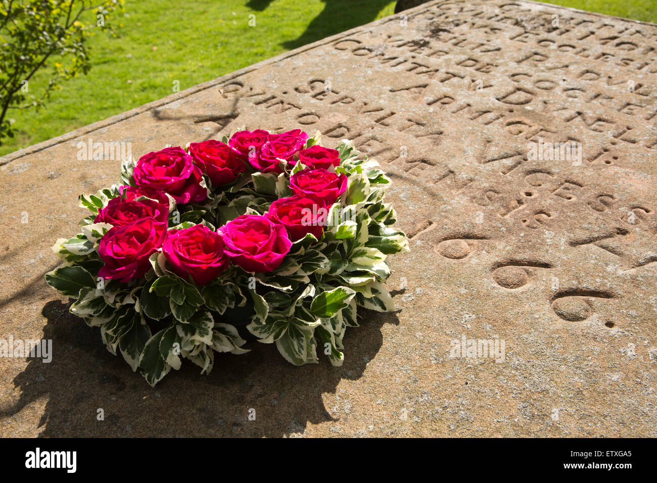 Regno Unito, Inghilterra, Derbyshire, Eyam, rose corona sul Catherine Mompesson la sua tomba, solo vittima della peste in St Lawrence il sagrato della chiesa Foto Stock