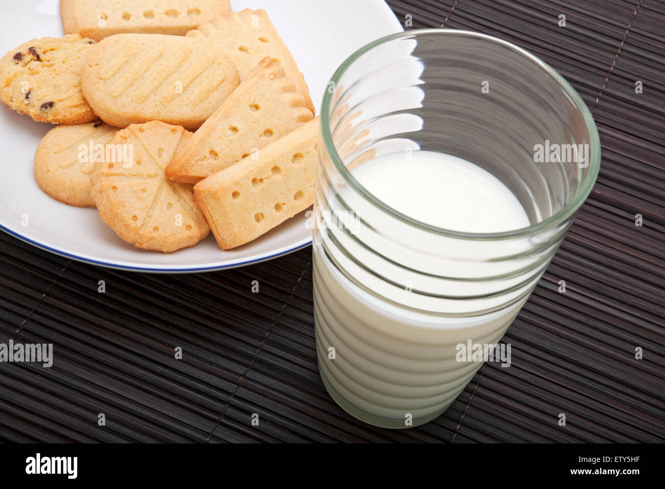 Primo piano di un bicchiere di latte freddo e biscotti frollini Foto Stock