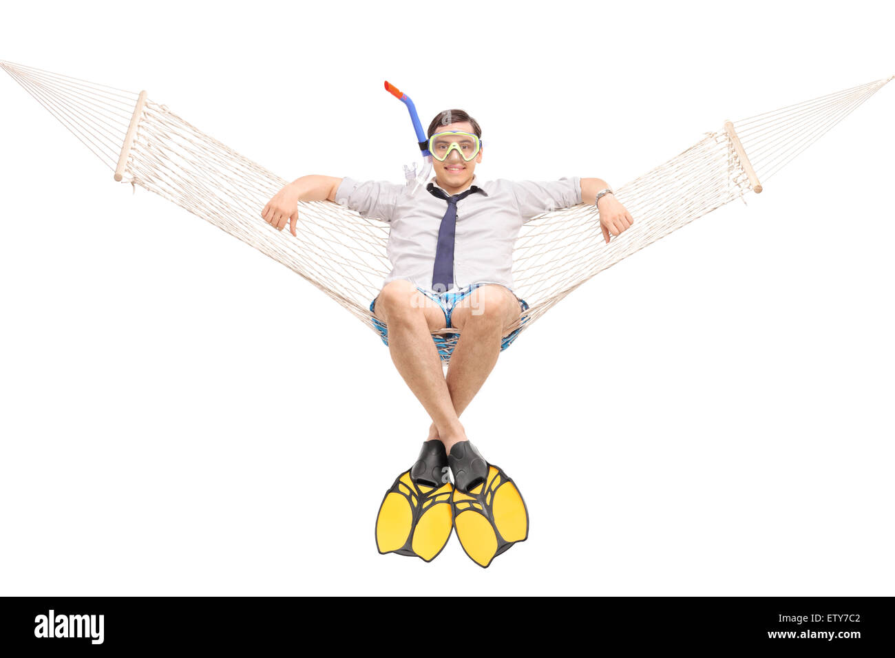 Studio shot di un giovane con un boccaglio e pinne per nuoto giacente in un amaca e guardando la telecamera Foto Stock