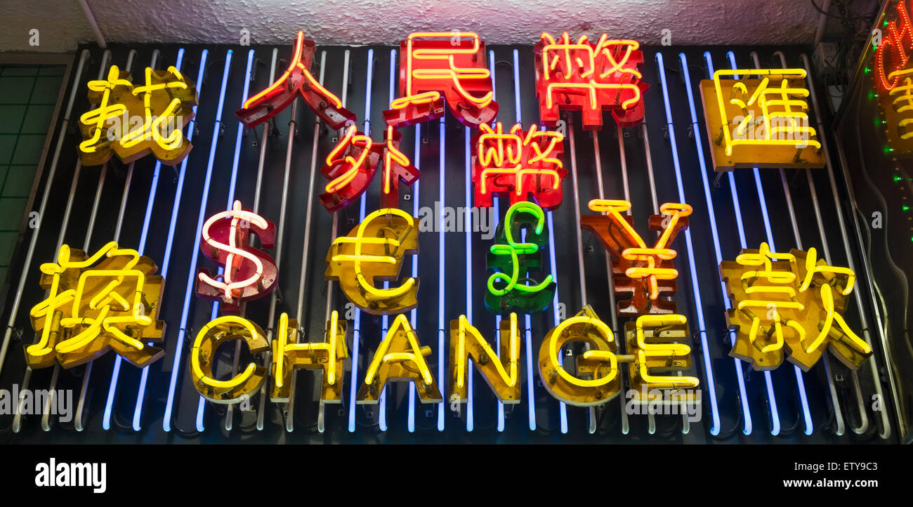 Luci al neon elencando varie monete al di sopra di cambio valuta Negozio di notte a Hong Kong Cina Foto Stock