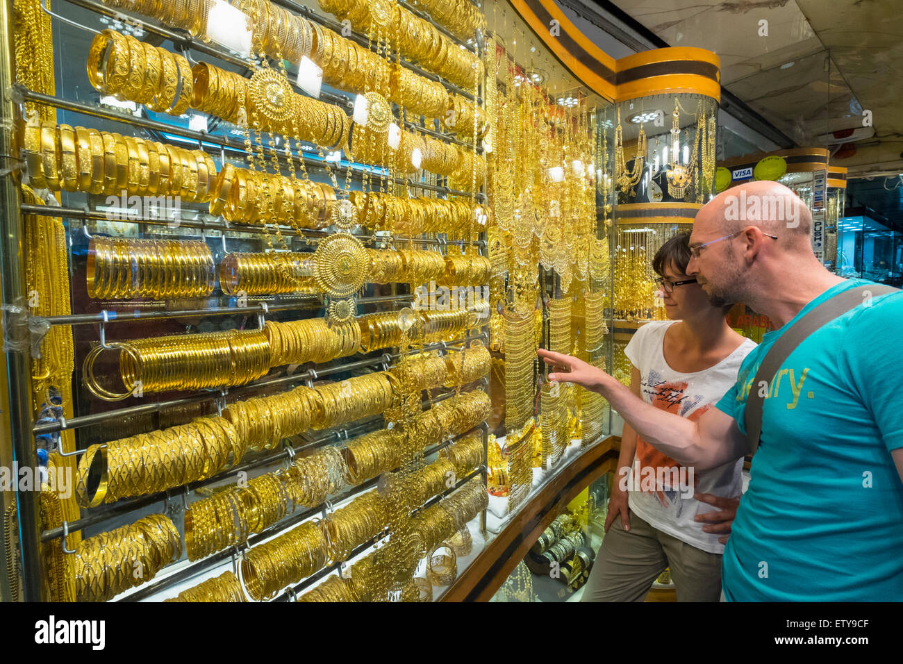 I turisti guardando la finestra di visualizzazione di ornati in oro gioielleria al Gold Souk in Deira Dubai Emirati Arabi Uniti Foto Stock