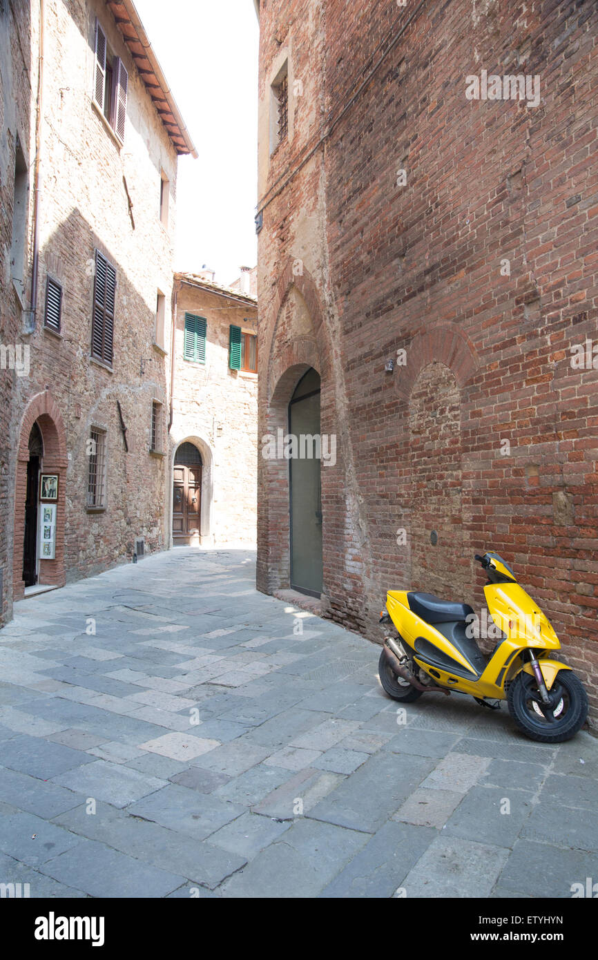 Scooter giallo in un vicolo a Montepulciano, Italia Foto Stock