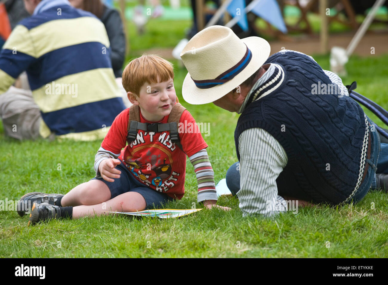 I visitatori la lettura sul prato a Hay Festival 2015 Foto Stock