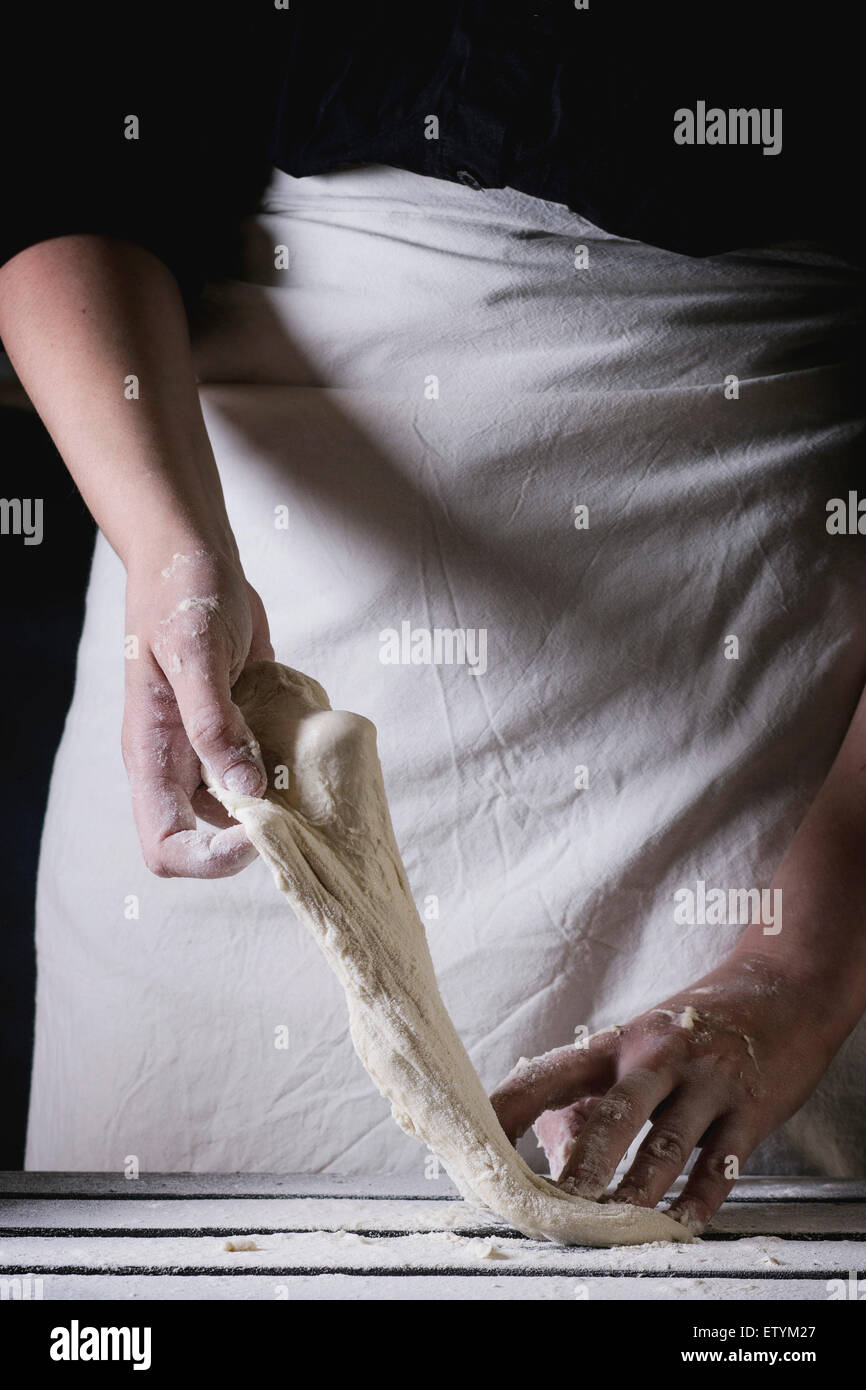 Le mani delle donne rendendo la pasta per pizza. Vedere serie Foto Stock