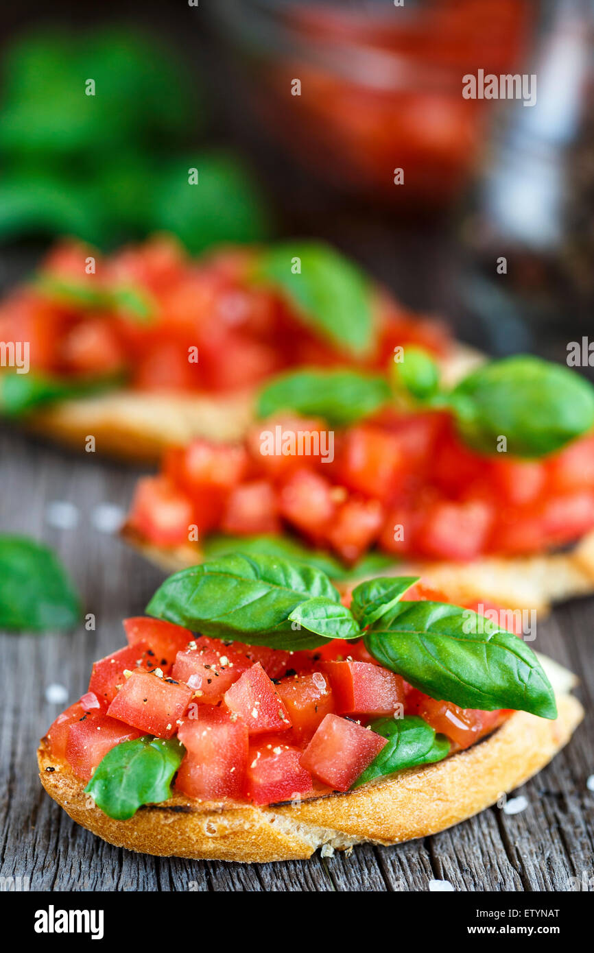 Bruschetta di pomodoro con un trito di pomodori e basilico sul pane tostato Foto Stock