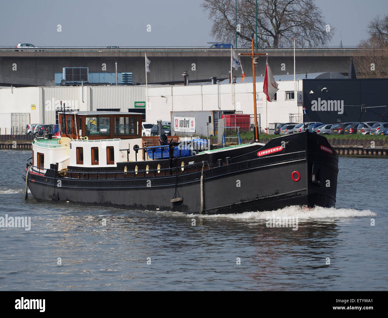 La "Linquenda", registrata con il numero ENI 03030877, è una petroliera che naviga nella zona di Amsterdam-Rijnkanaal. Questa immagine cattura l'imbarcazione nella trafficata via d'acqua, tipica dell'industria navale europea. La nave è vista vicino al porto, con rimorchiatori che assistono il suo movimento, evidenziando le operazioni delle navi cargo in questa vitale rotta commerciale. Foto Stock