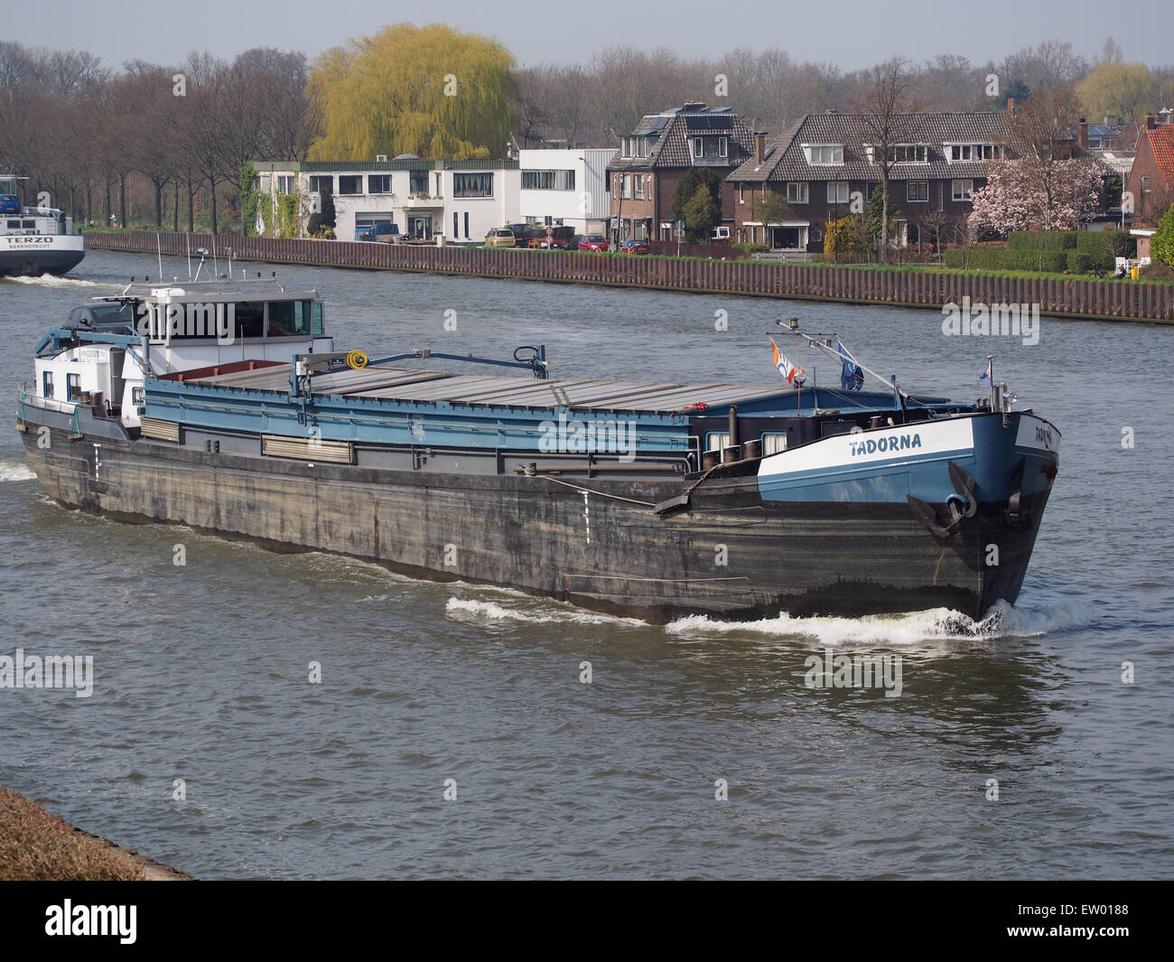 La Tadorna è una petroliera immatricolata ENI 02315870, che opera sulla Amsterdam-Rijnkanaal. L'immagine cattura la nave in transito lungo il canale, un'importante via d'acqua per il trasporto di merci all'interno dei Paesi Bassi. La foto mostra la scala e il design della petroliera mentre si muove lungo il trafficato percorso industriale. Foto Stock