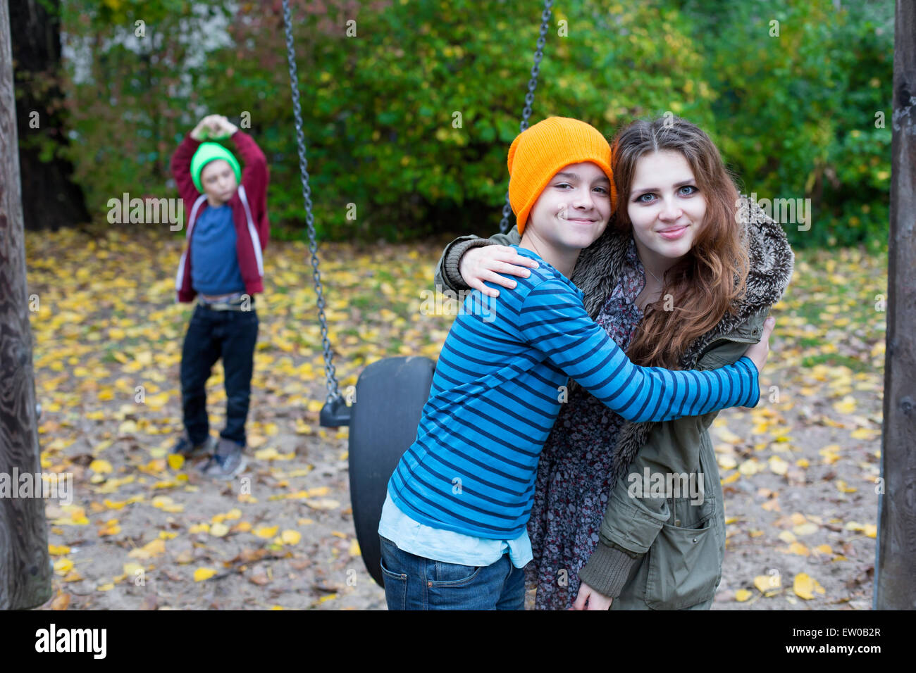 Ragazza adolescente e due ragazzi su un parco giochi Foto Stock