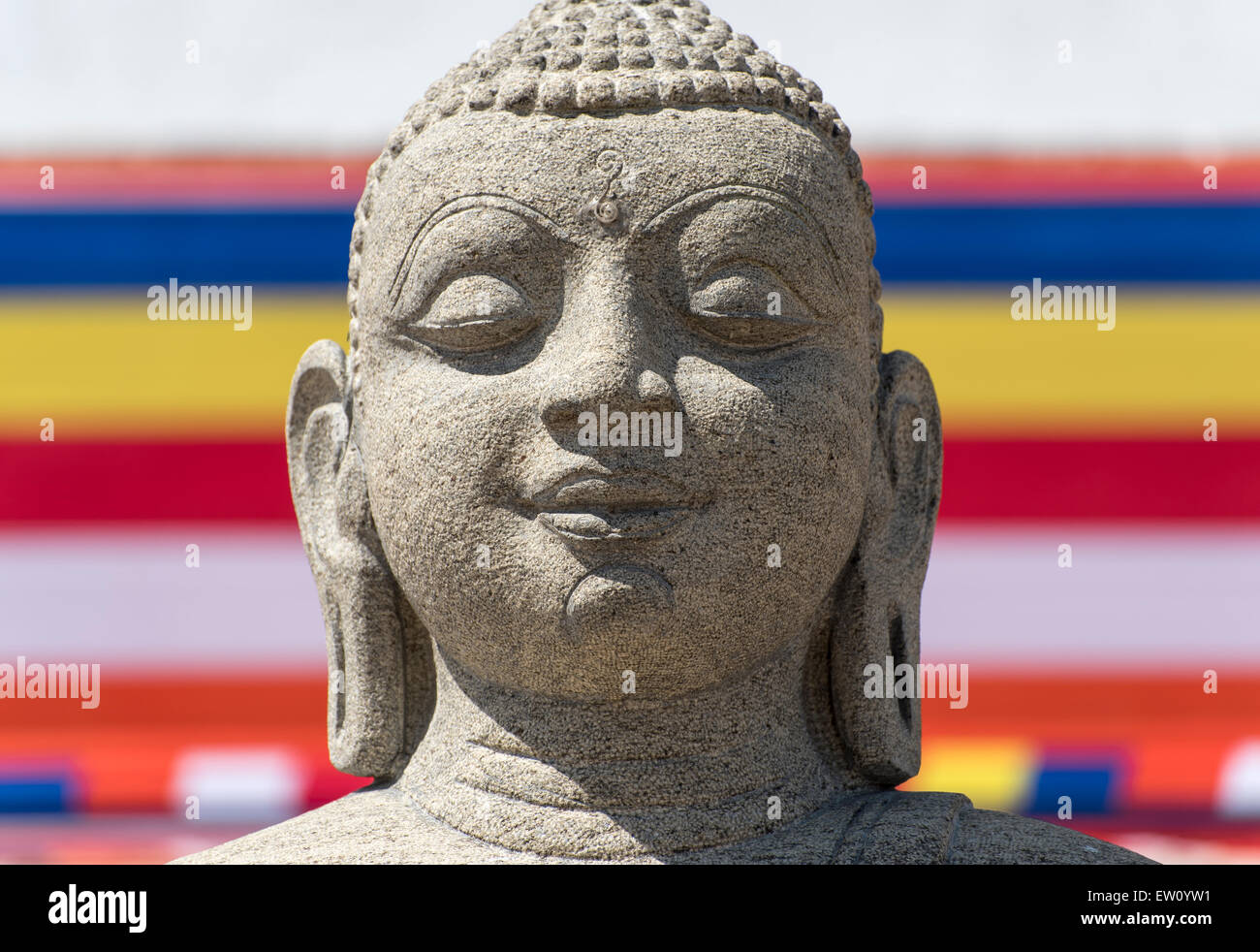 Bandiera buddista e la statua del Buddha, Ruwanwelisaya (Ruwanweli Maha Seya) Stupa, Anuradhapura, Sri Lanka Foto Stock