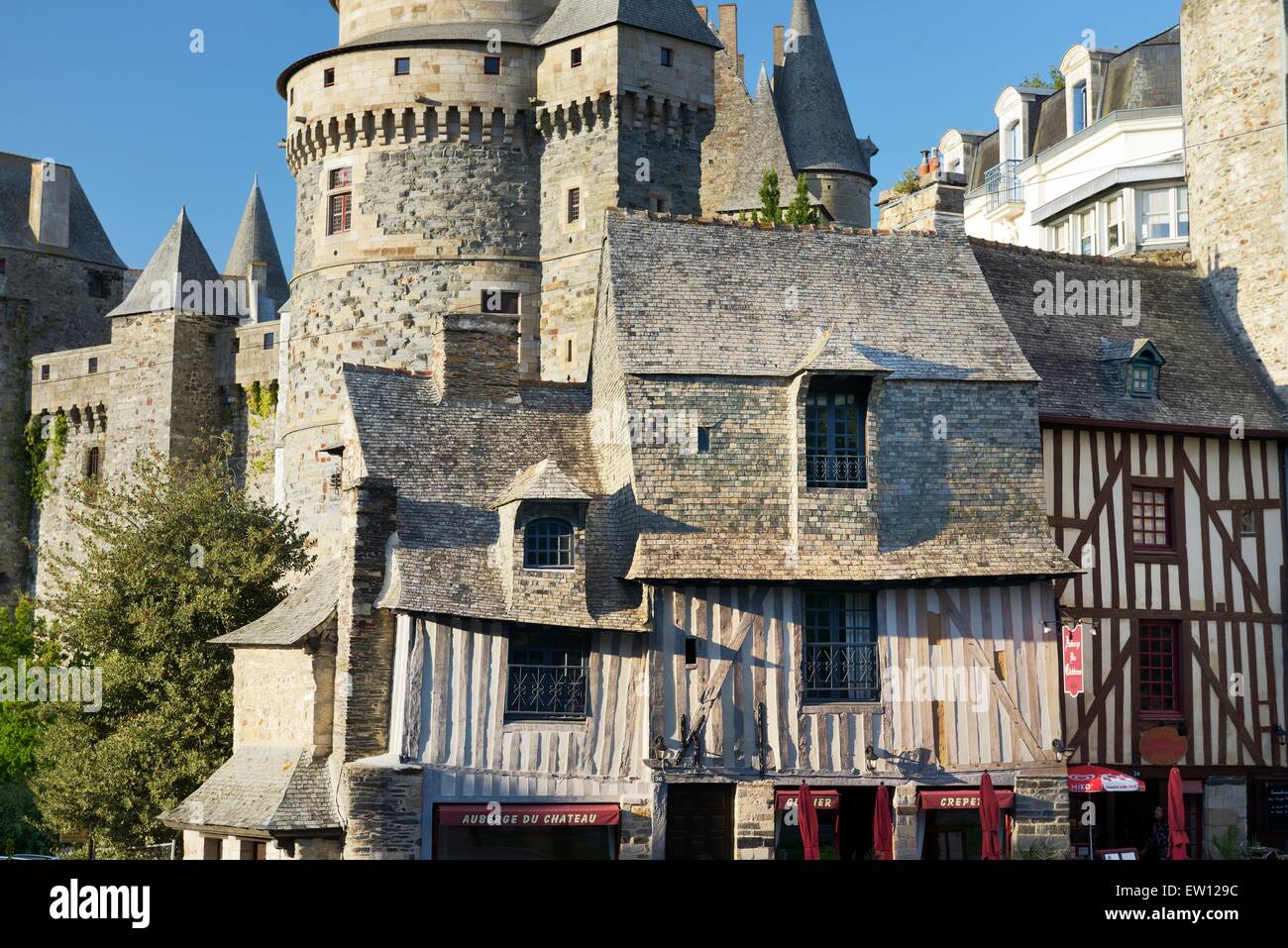 Il francese la città medievale di Vitre, Brittany. Il castello di Vitre Chateau sorge dietro il graticcio facciata dell'Auberge du Chateau Foto Stock