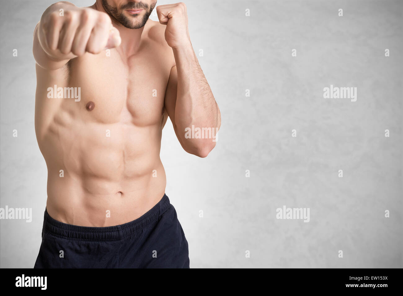Boxer maschio pronto a combattere, isolato in grigio Foto Stock