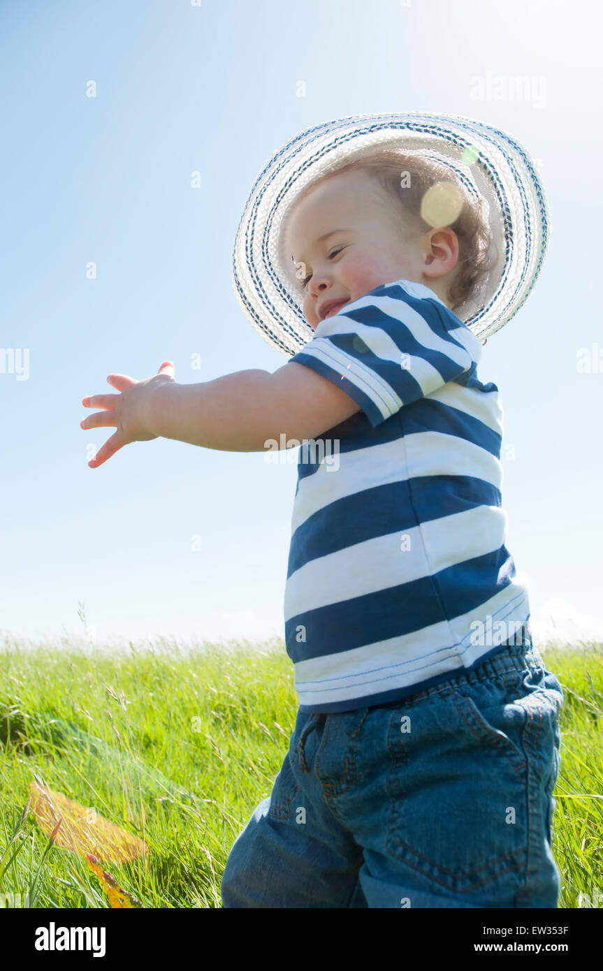 Bambino in striped t-shirt in un campo di sole Foto Stock