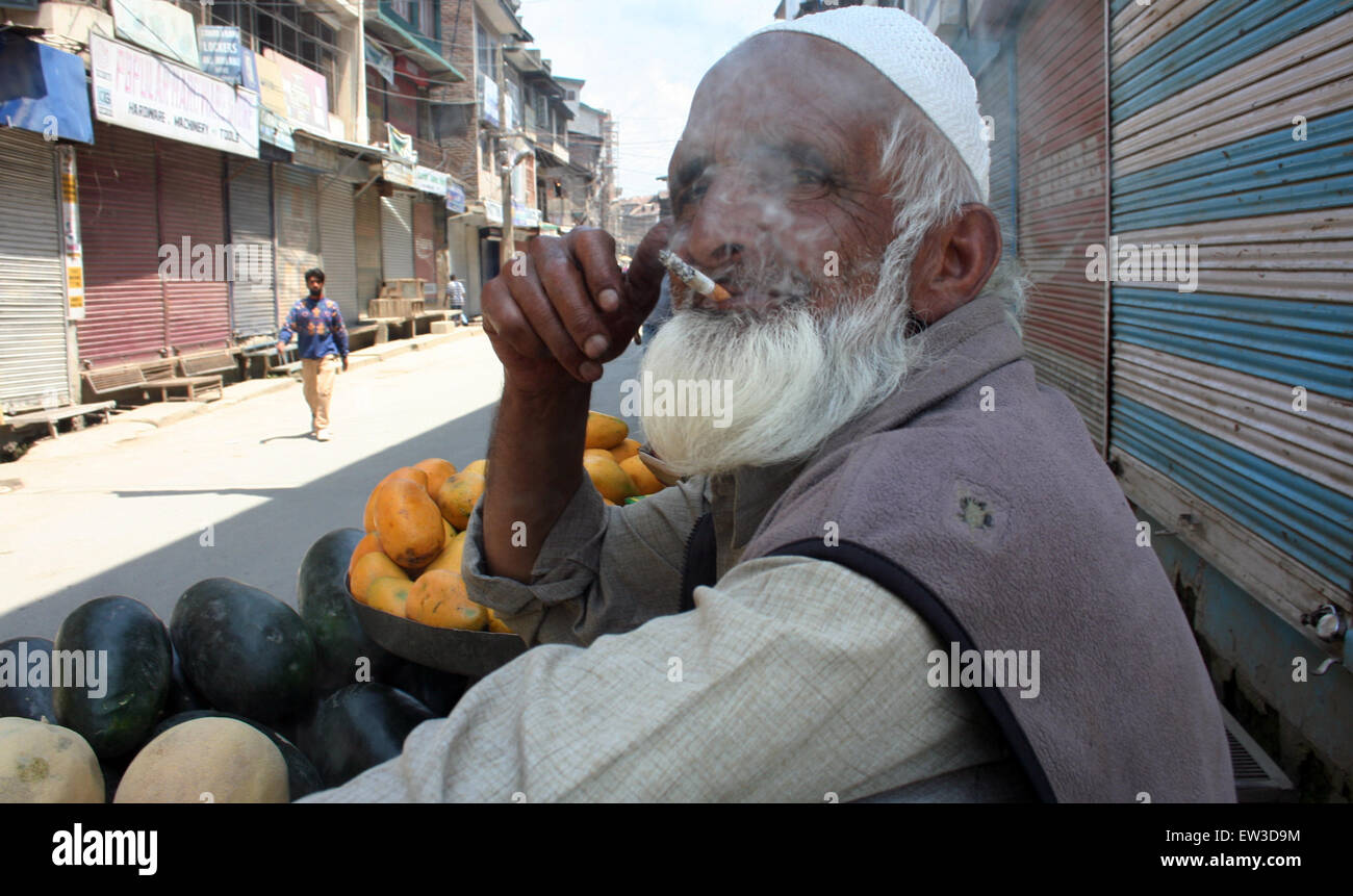 Srinagar, Indiano Kashmir amministrato:17Giugno .una vecchia strada laterale in attesa del fornitore per i clienti come lui di fumare in tra negozi chiuse durante uno sciopero , negozi, aziende e scuole sono rimaste chiuse a causa dello sciopero chiamato congiuntamente da JKLF, Hurriyat Conference fazioni guidato da Mirwaiz Umar Farooq e Syed Ali Shah Geelani e supportato da quasi tutti i gruppi separatisti nella valle di credito: Sofi Suhail/Alamy Live News Foto Stock