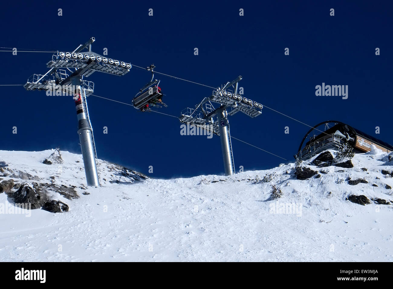 Vista dello sci la seggiovia che porta gli sciatori visto da sotto contro un cielo blu scuro Foto Stock