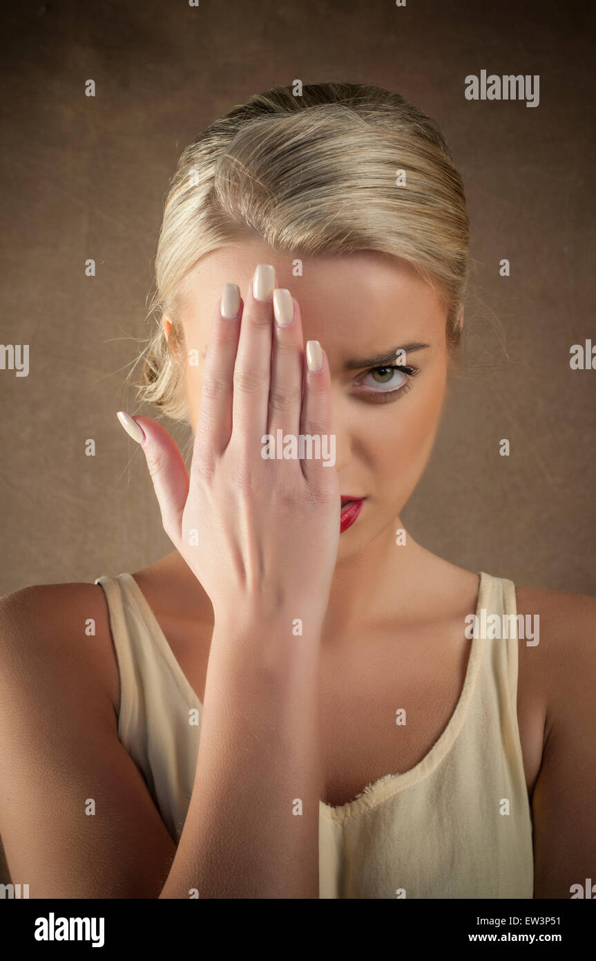 Giovane donna nascondendo la faccia con la mano Foto Stock