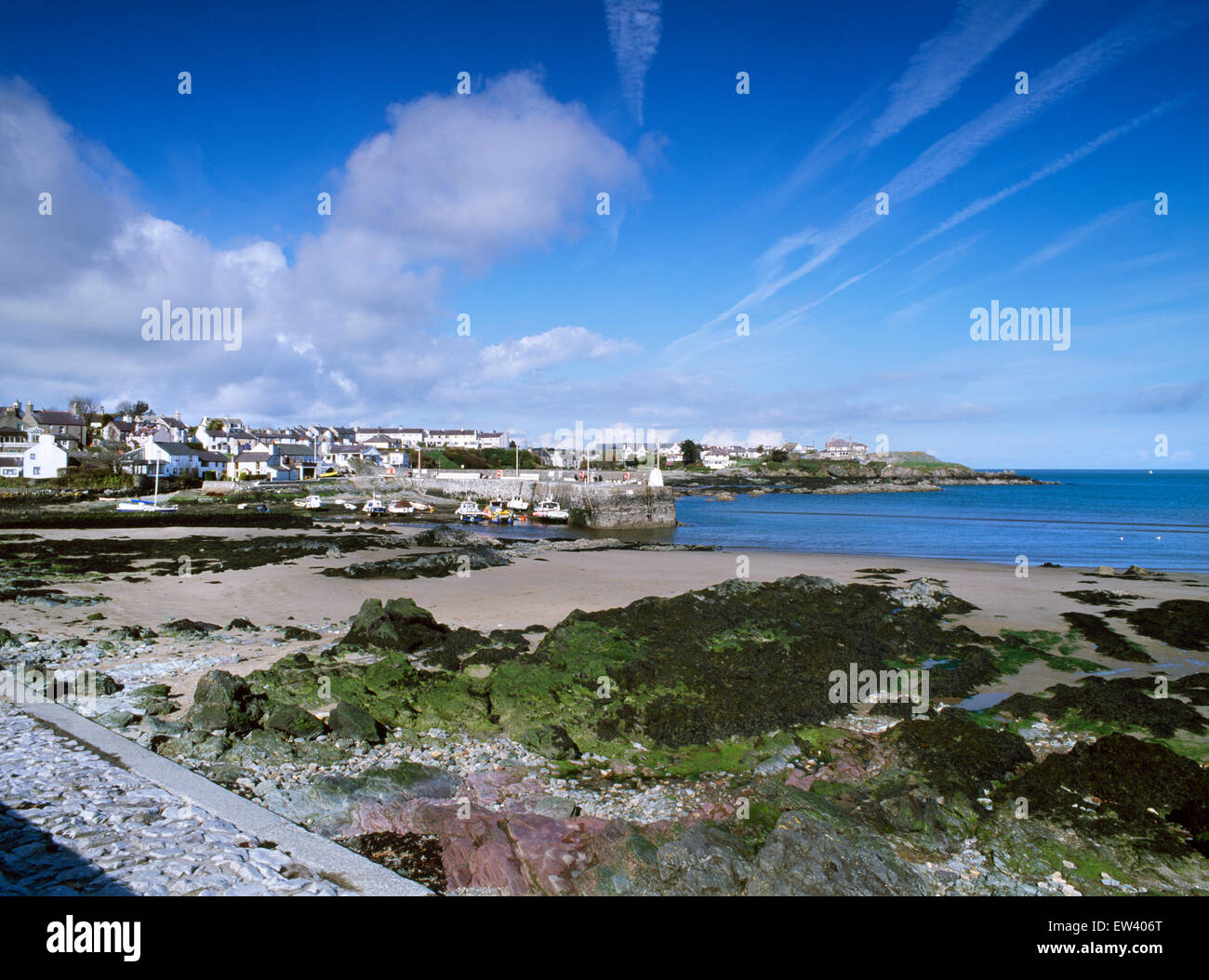 Cemaes Porto e villaggio sulla costa nord di Anglesey, Galles del Nord, Regno Unito; visto dalla spiaggia. Foto Stock