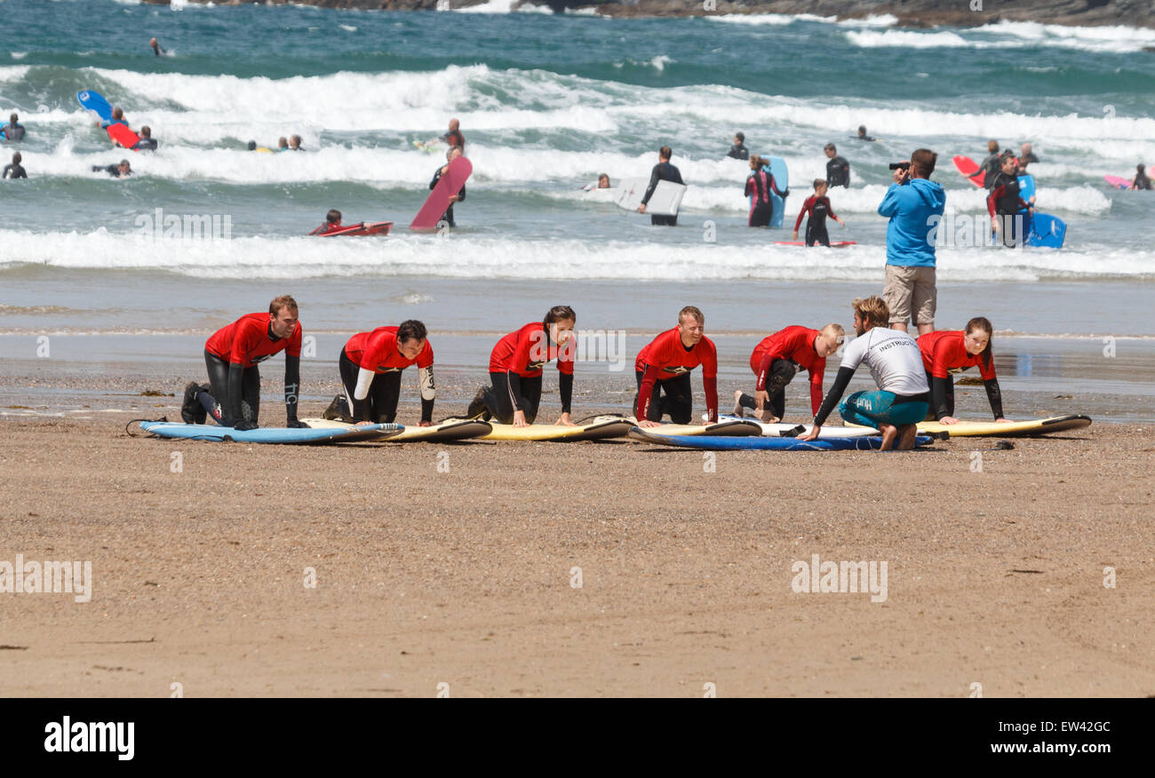 Scuola di Surf lezioni di surf sulla spiaggia di Polzeath Cornwall, Regno Unito, gli studenti sono inginocchiati sulle loro tavole da surf Foto Stock