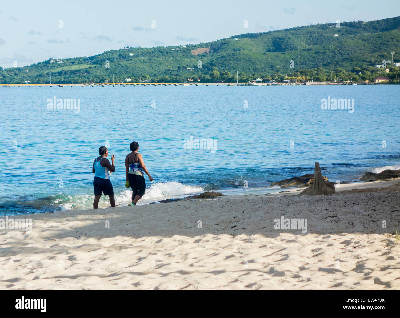 Due americano africano donne nel loro 50s a piedi sulla spiaggia di west end di St. Croix, U.S. Isole Vergini. Foto Stock
