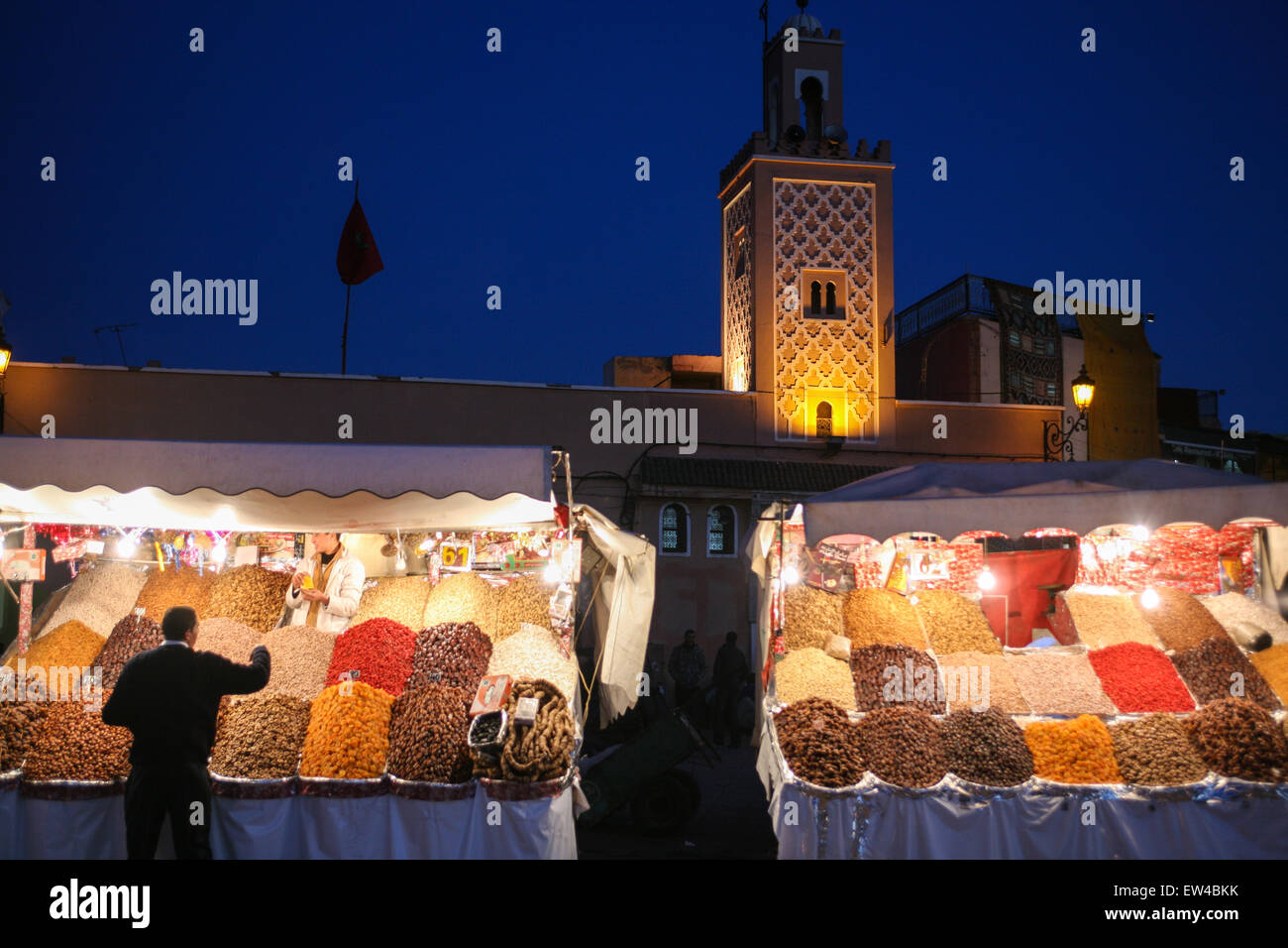 Frutta e noci per vendita a questo stallo di strada su,Djemaa, Djamaa El Fna con moschea in background, la piazza principale di Marrakesh, Moro Foto Stock