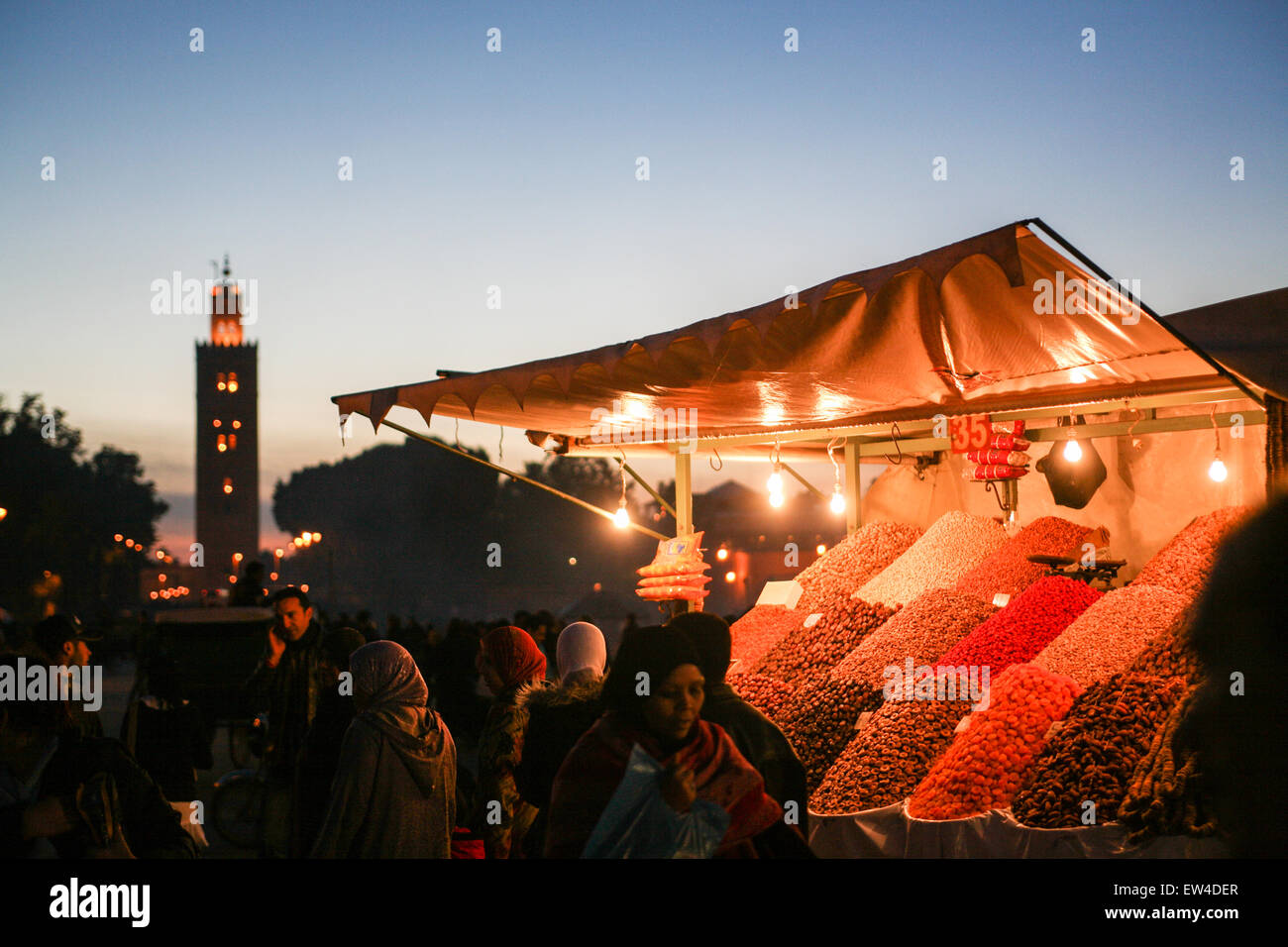 Frutta e noci per vendita a questo stallo di strada su,Djemaa, Djamaa El Fna,la piazza principale di Marrakesh con minareto della moschea di Koutoubia, il Foto Stock
