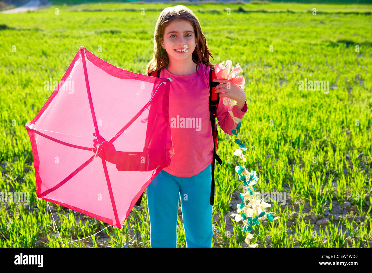 Kid ragazza con rosa tradizionale aquilone in primavera su prato Foto Stock