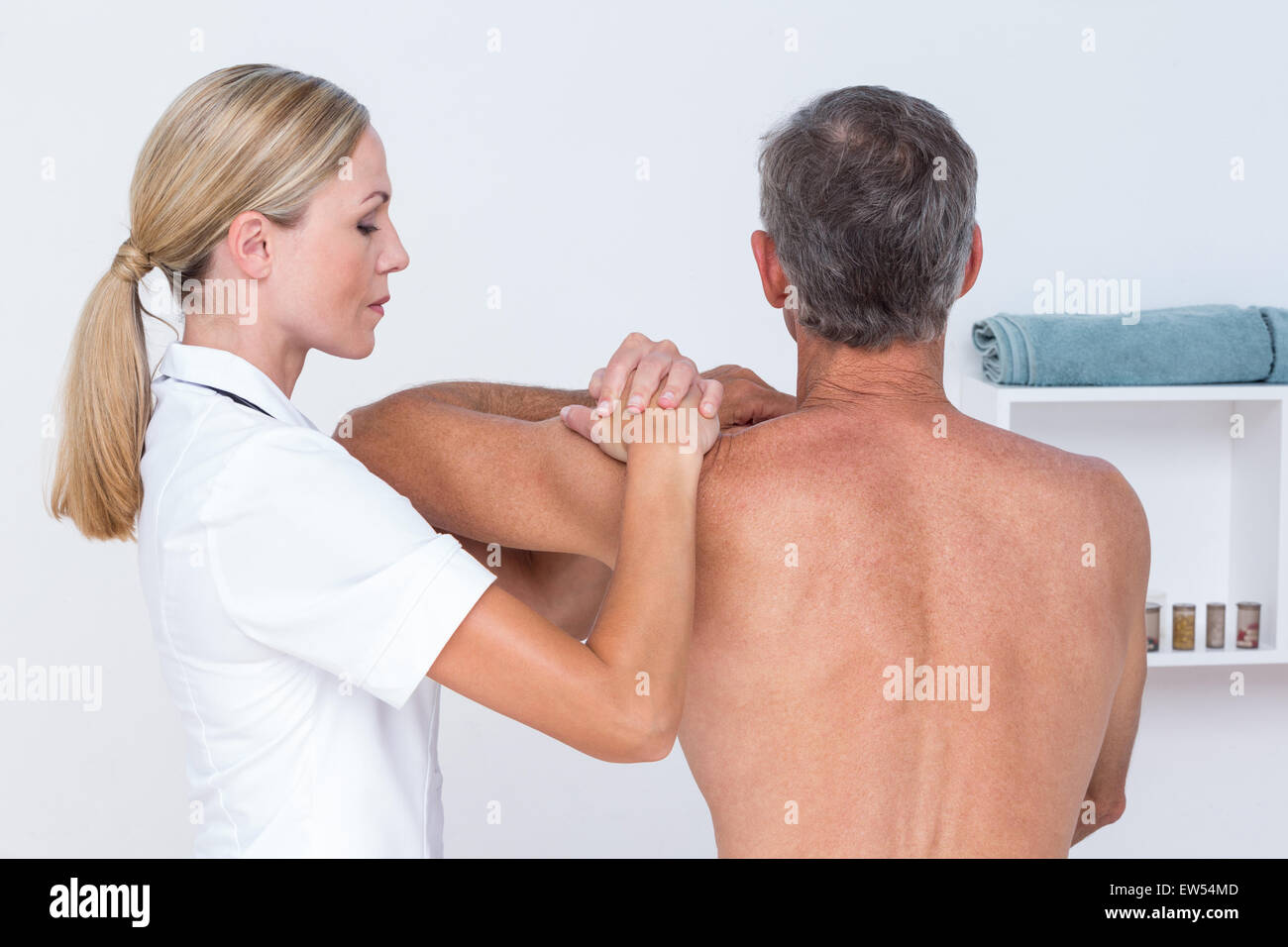 Medico di esaminare la sua spalla del paziente Foto Stock