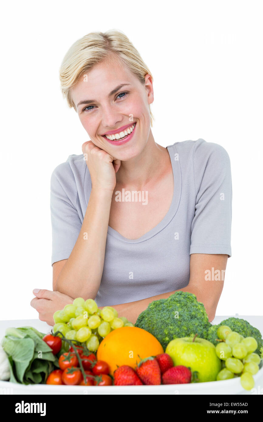 Felice donna bionda seduta al di sopra di un alimento sano Foto Stock