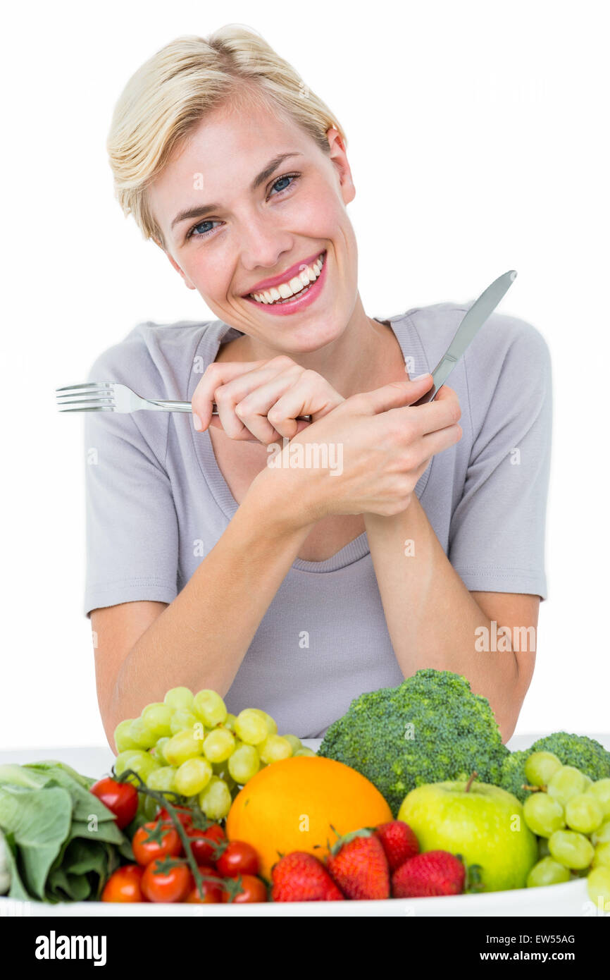 Felice donna bionda seduta al di sopra di un alimento sano Foto Stock