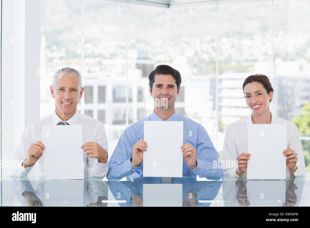 Sorridente team aziendale che mostra la carta Foto Stock