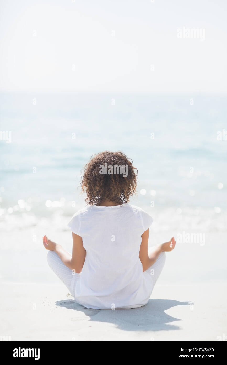 Donna felice fare yoga in riva al mare Foto Stock