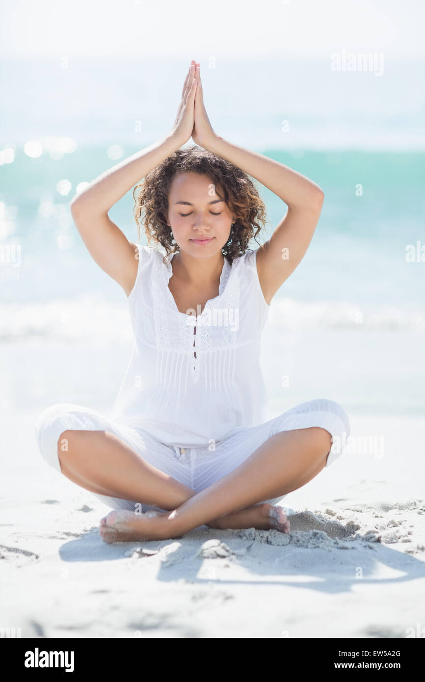 Donna felice fare yoga in riva al mare Foto Stock