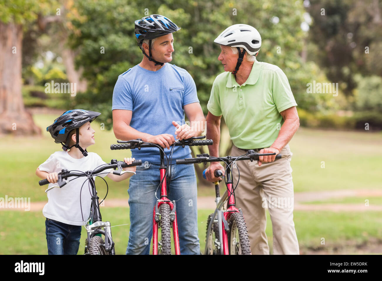 Felice multi generazione famiglia sulle loro moto al parco Foto Stock