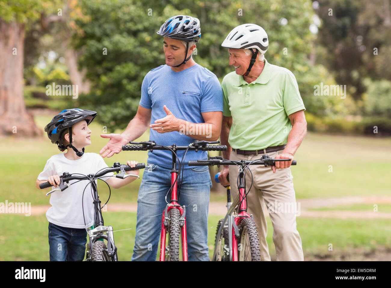 Felice multi generazione famiglia sulle loro moto al parco Foto Stock