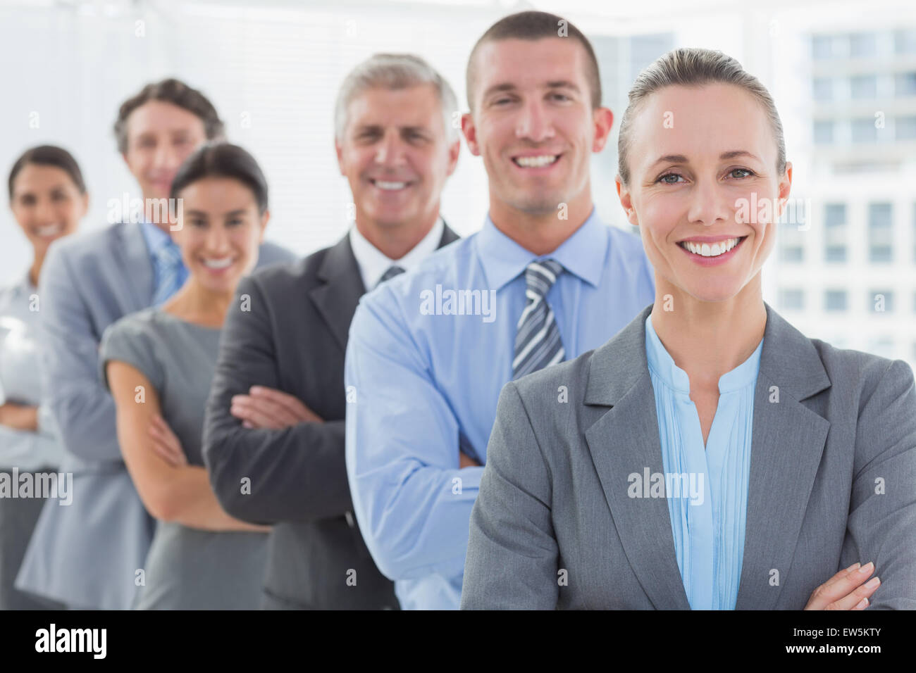 Sorridente team aziendale in piedi in una linea Foto Stock