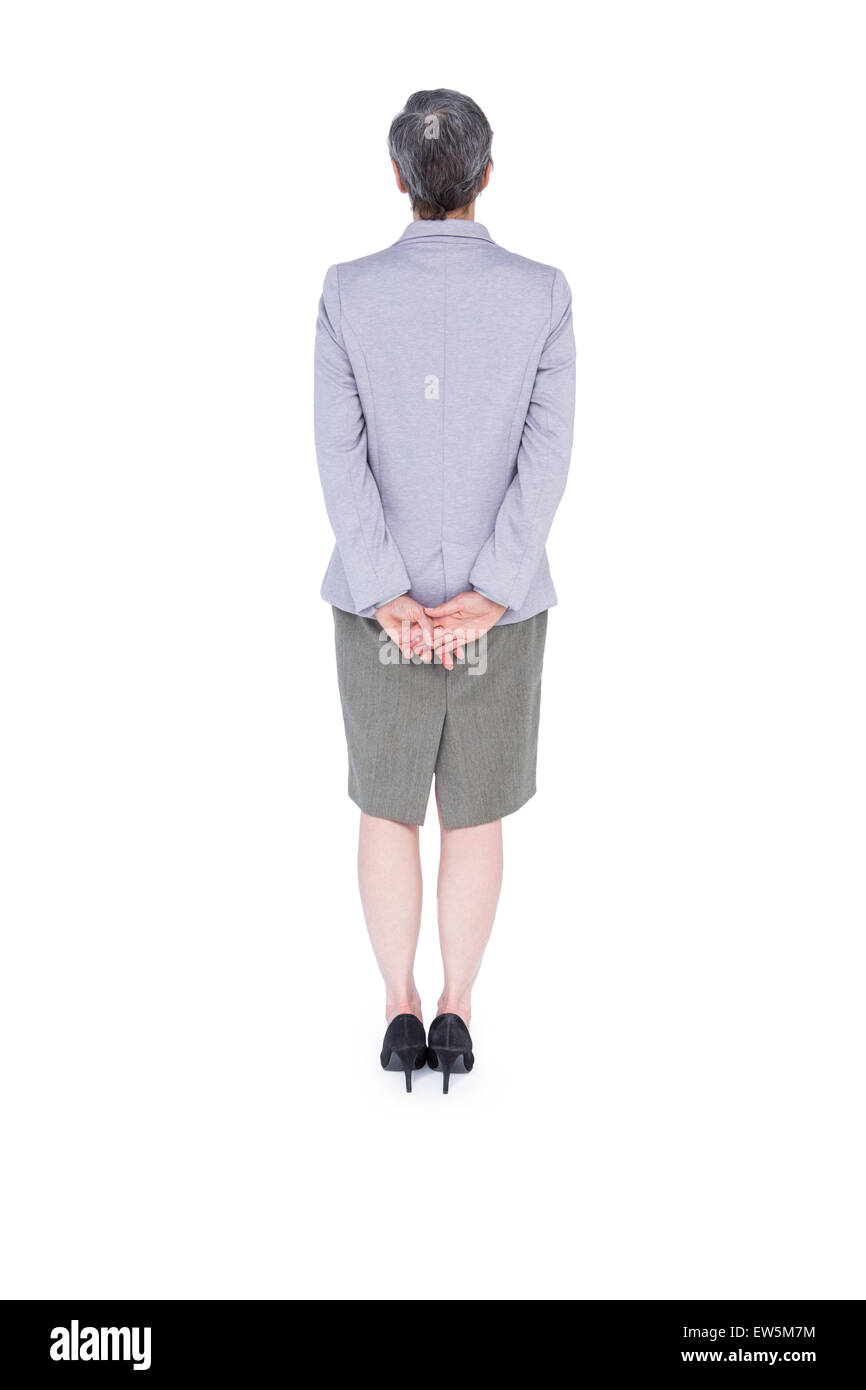Vista di usura di imprenditrice in piedi con la mano sul retro Foto Stock