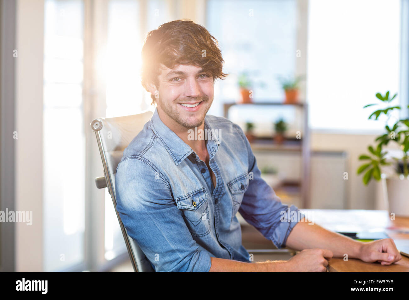 Sorridente imprenditore informale seduti alla scrivania Foto Stock