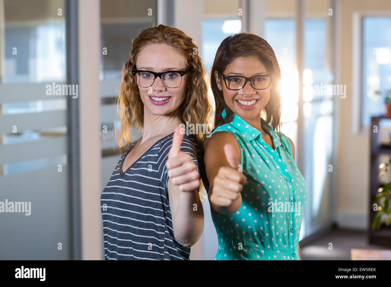 Ritratto di partner sorridente in posa insieme pollice in alto Foto Stock