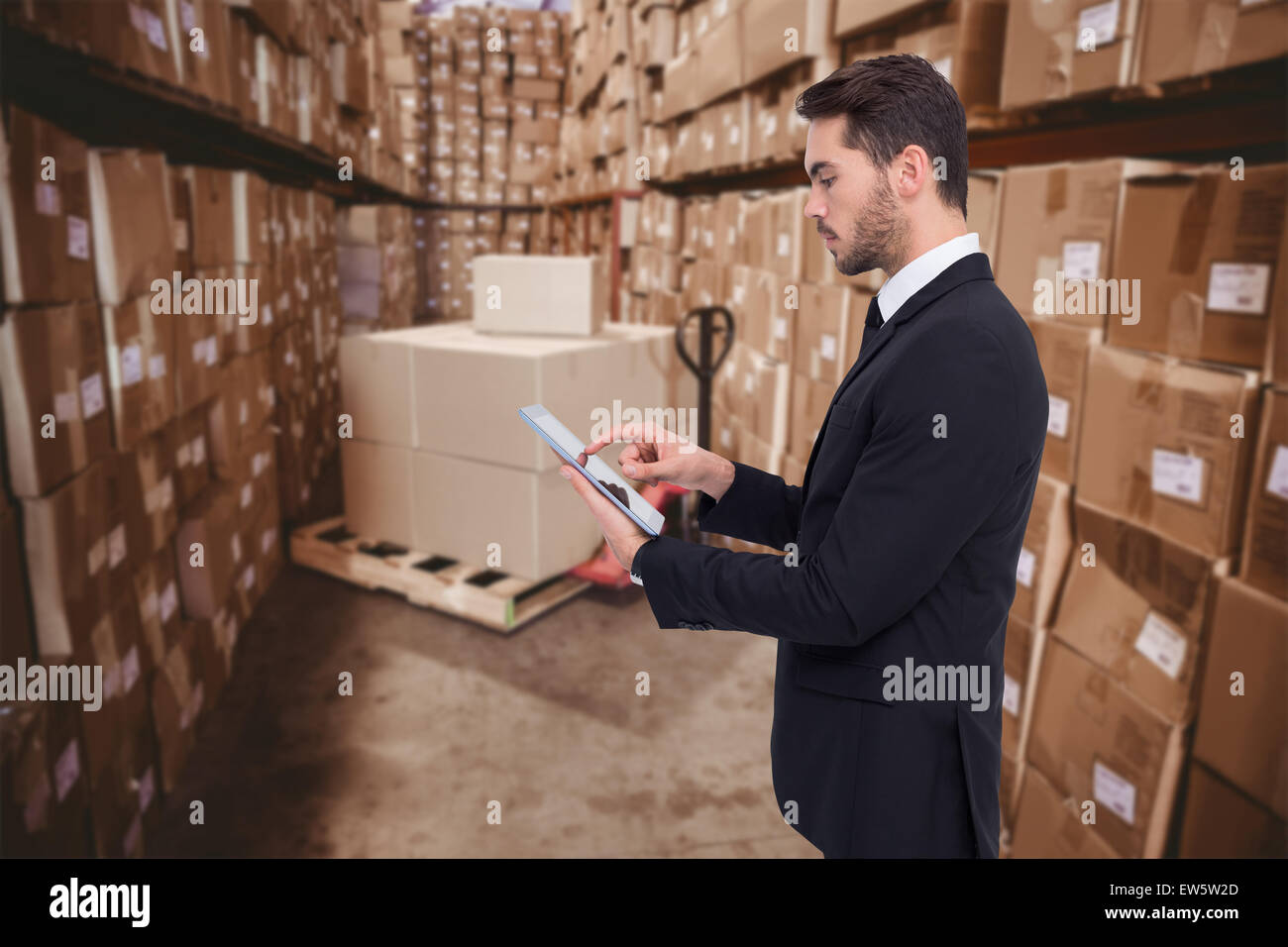 Immagine composita di concentrato di imprenditore di toccare il suo tablet Foto Stock