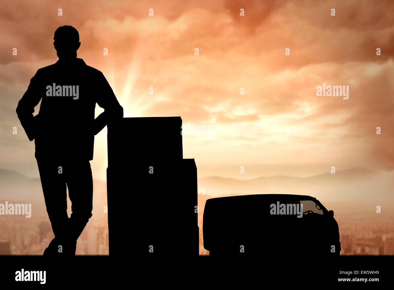 Immagine composita di consegna sorridente uomo in piedi dalla pila di scatole Foto Stock