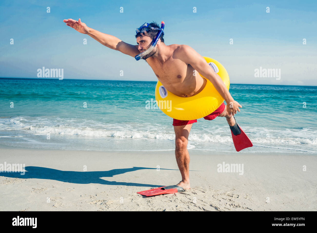 L'uomo indossare pinne e anello in gomma in spiaggia Foto Stock